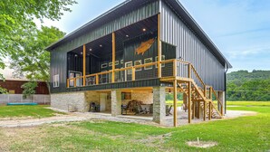 A modern building with a large open space, a staircase, and a view of the surrounding landscape. - Relax on the River: Modern Mountain View Escape! (Mountain View)