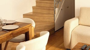 A staircase with a wooden finish and metal railing, leading to a room with a dining table and chairs. - Amazing Apartment - 2br/6p - Nation (Paris)