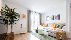 A modern living room with a sofa, a coffee table, and a large window.
