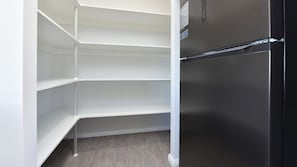 A kitchen with a built-in black refrigerator and white shelving units. - Huntlee Heights | {et Friendly with Fire Pit (North Rothbury)