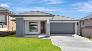 A modern two-story house with a garage, a front door, and a driveway.