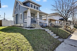 A two-story house with a front porch, a garage, and a small front yard.