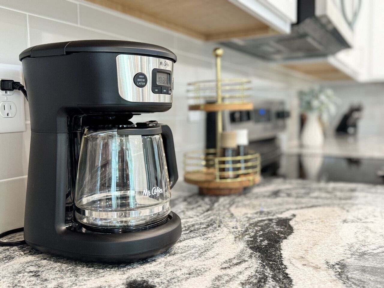 En Mr. Coffee espressomaskine på en barlåsebordplade i et køkken.