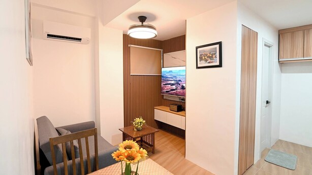 A compact living space with a dining area, a television, and a wooden cabinet.