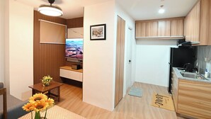 A compact living space with a kitchenette, a dining area, and a television.
