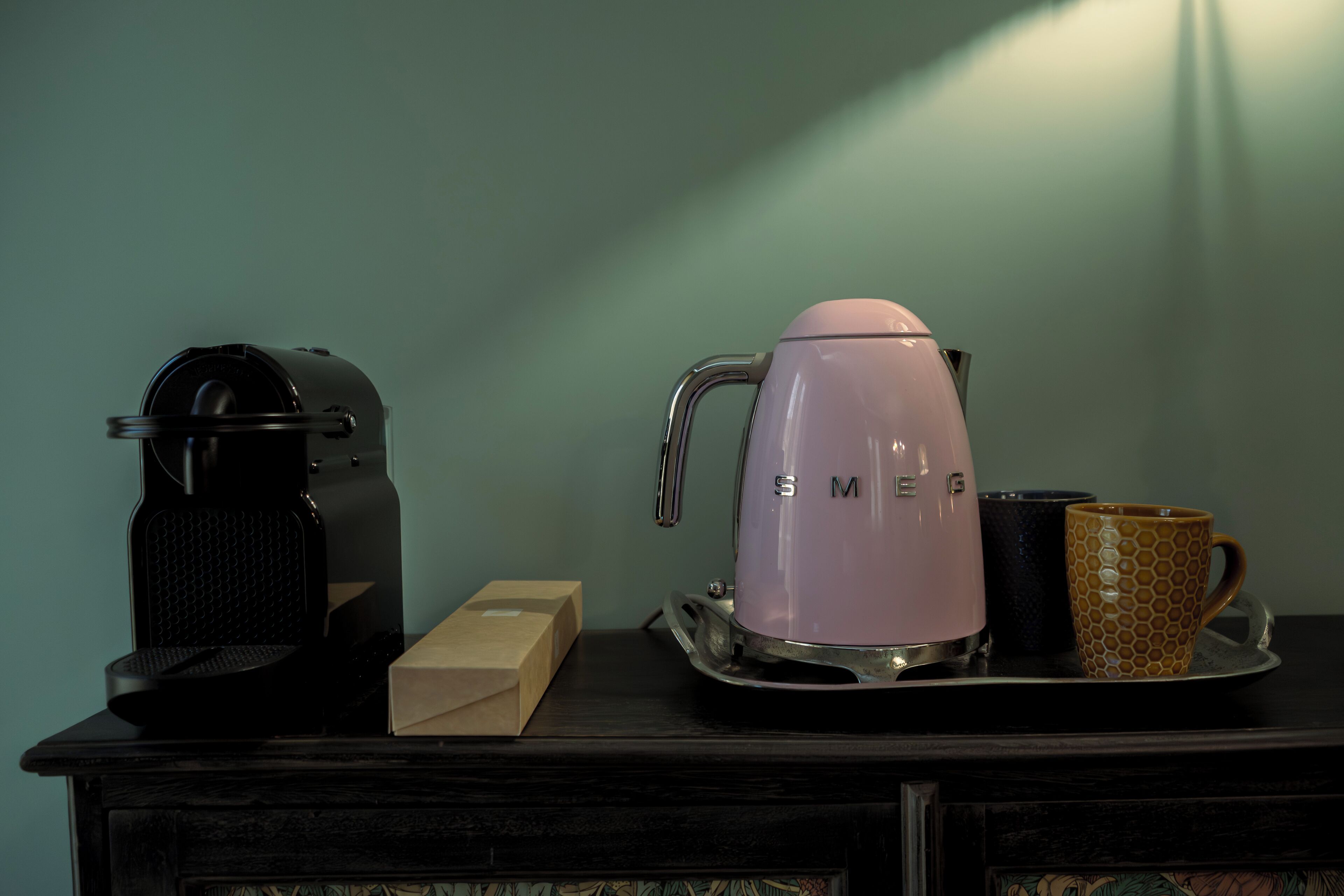 Une machine à café, une tasse et une boîte sur un plateau.