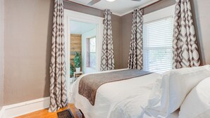 A bedroom with a bed, curtains, a ceiling fan, and a window with blinds. - Beautiful Duplex In Kansas City! 13&14 v2 (Kansas City)