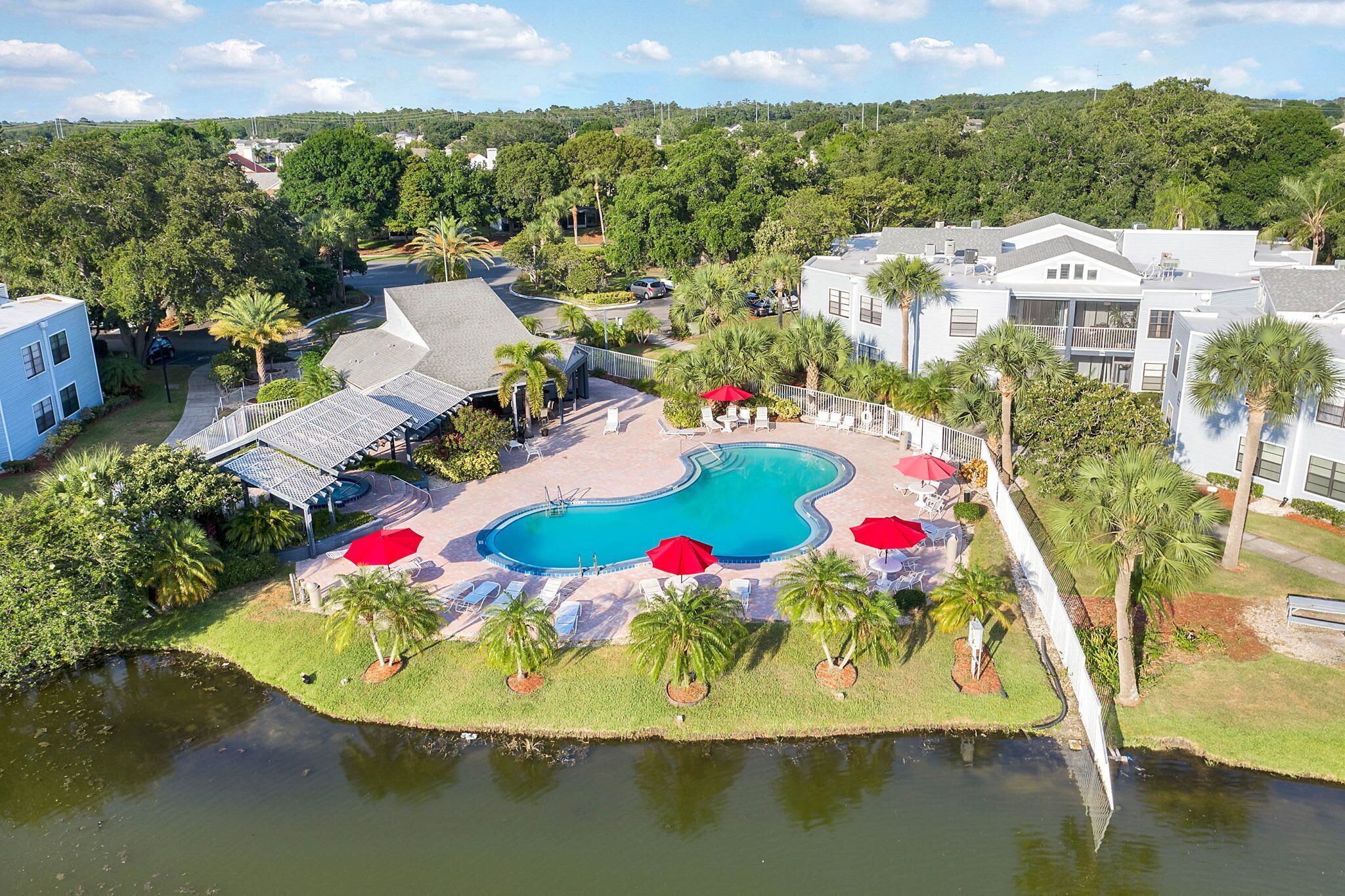 Un resort con piscina, palmeras y vistas del paisaje circundante.