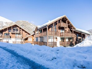 A chalet-style building with multiple balconies and a ski slope in the foreground. - Resort center, 1st floor, terrace, balcony, ski locker, 30m², Valloire (Valloire)