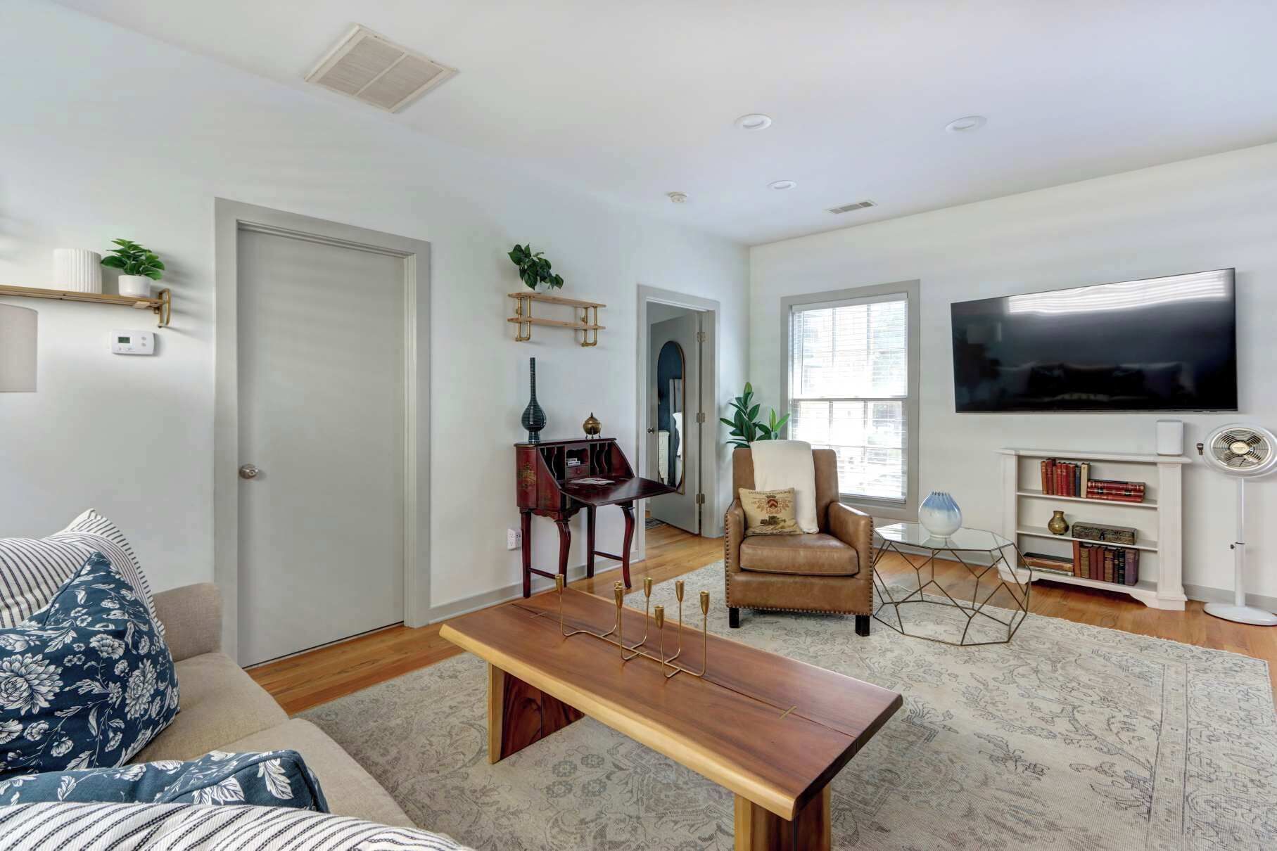 A living room with a sofa, a wooden coffee table, a TV, and a bookshelf.