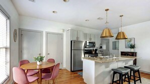 A modern kitchen with a central island, stainless steel appliances, and pendant lighting.