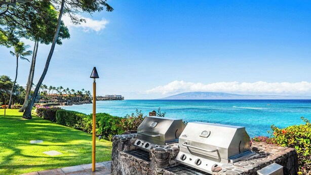 Un barbecue en pierre avec vue sur l’océan et un ciel dégagé.