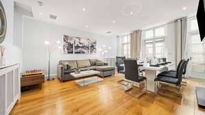 Un salon moderne comprenant un canapé, une table basse et un coin repas avec des chaises et une table.