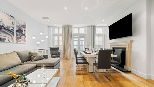 Un salon moderne avec un canapé, une table basse et un coin repas.