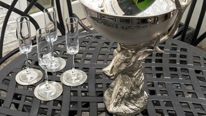 Une table avec une chaise en métal, un bol de glaçons, une bouteille de champagne Moët et quatre verres à vin vides.