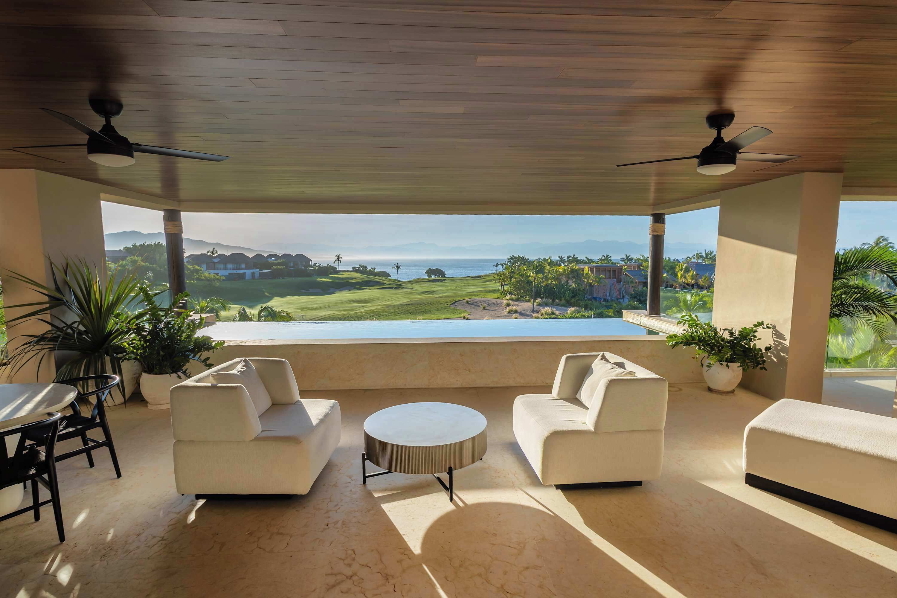 A modern lounge area with a view of a golf course and ocean.