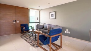A modern living room with a grey sofa, blue armchairs, and a coffee table. - Family Residencia Galicia (La Tijera)
