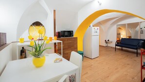 Un espace de vie compact comprenant une cuisine, un coin repas et un coin salon.