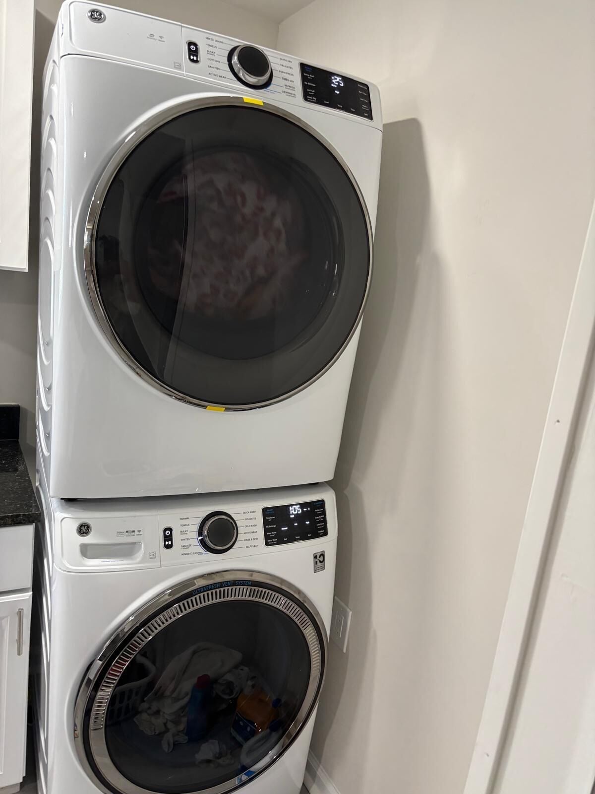 A stacked washer and dryer unit in a laundry room.