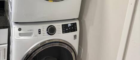 A stacked washer and dryer unit in a laundry room.