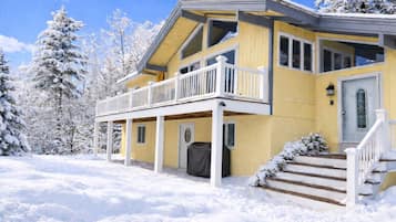 A two-story house with a balcony, a covered front door, and steps leading to the entrance.
