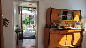 A kitchen with wooden cabinets, a sink, and a countertop. - Studio with terrace and garden 15 minutes from Guédelon (Treigny-Perreuse-Sainte-Colombe)