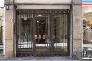 A building entrance with a metal gate and a number '7' sign. - Old Bridge Exclusive Apartment  (Firenze)