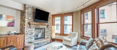 Smart-tv, eldstad, böcker och ett musikbibliotek