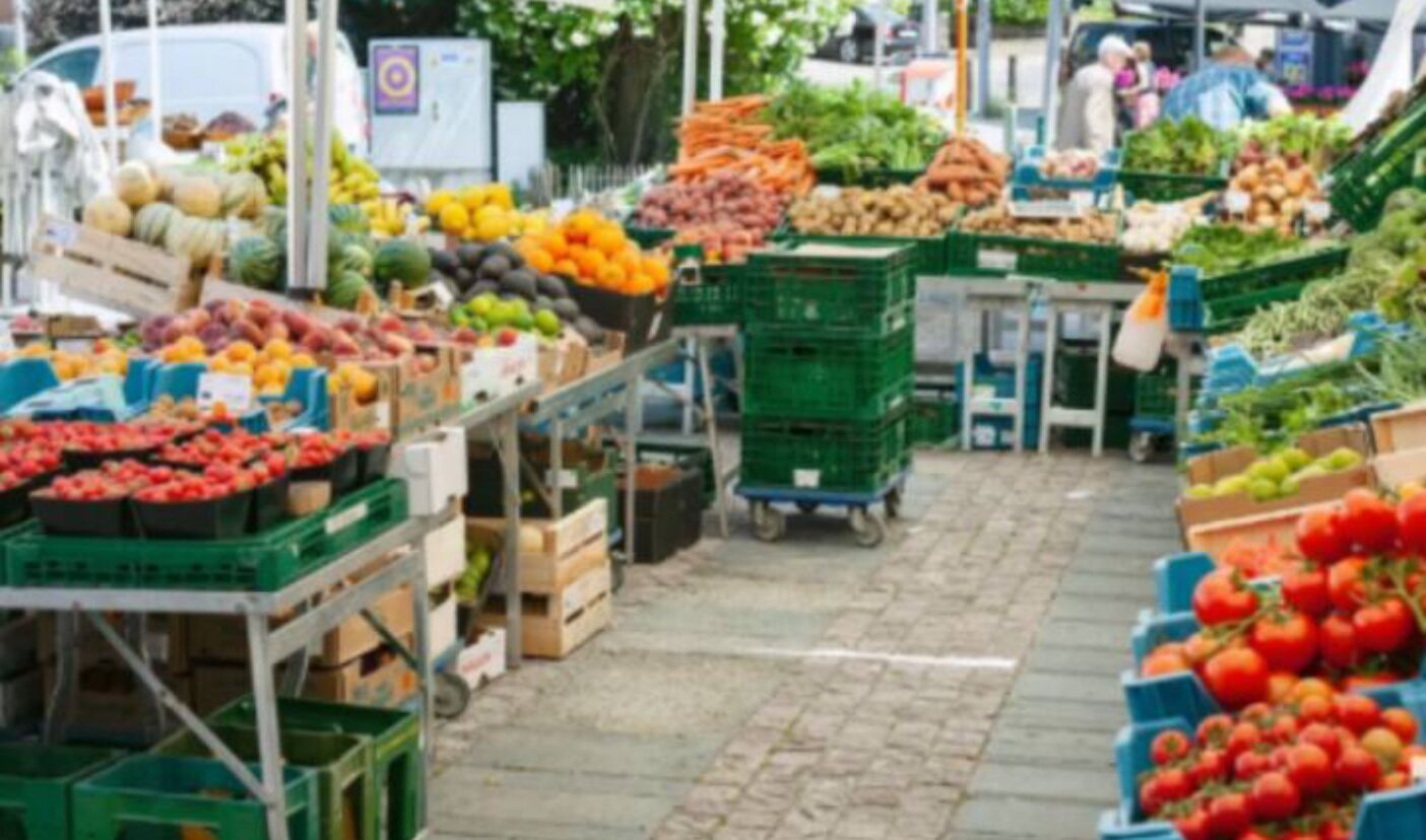 A market with various fruits and vegetables displayed in crates and boxes.