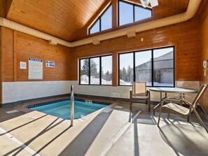 Ein Holzinterieur mit Pool, Stühlen und Blick ins Freie.