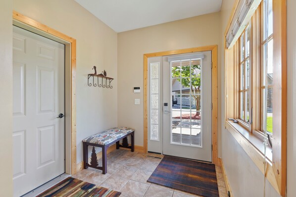 A hallway with a bench, a door, and a window with a view of the outside. - Unit #838 Resort Amenities| Beach, Pool, Firepits (Crosslake)