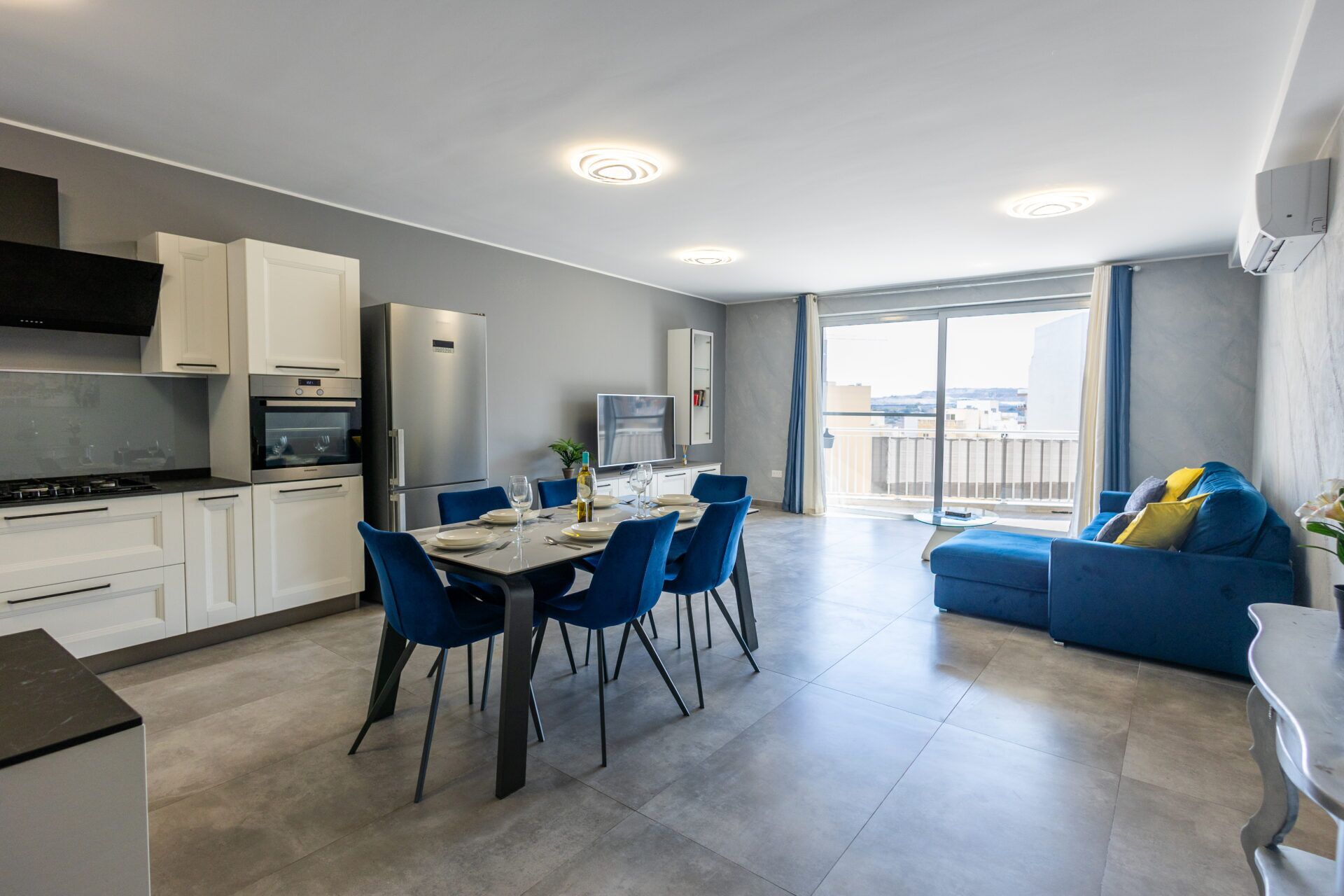 Eine moderne Wohnung mit Küche, Essbereich und Wohnzimmer. Sie verfügt über einen Balkon mit Blick.