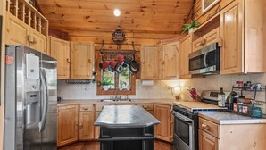 A kitchen with wooden cabinets, stainless steel appliances, and a central island.