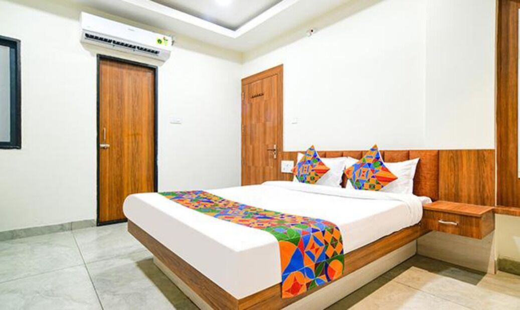 A bedroom with a bed, wooden headboard, bedside table, and a nightstand.