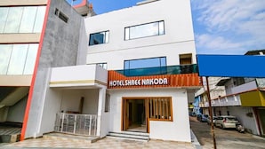 Un hôtel moderne, reconnaissable à son enseigne bien visible où l’on peut lire « HOTELSHREE NAKODH ».
