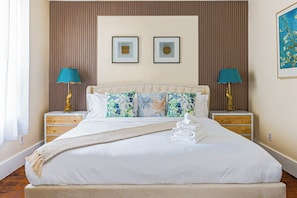 A hotel room with a large bed, two bedside tables, a headboard, and two wall-mounted lamps. - Luxury 3BR/3BA•Air Hockey Lounge•Walkable Old City (Philadelphia)