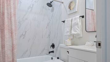 A bathroom with a bathtub, toilet, and a shower.