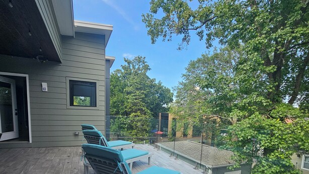 A deck with lounge chairs and a table, overlooking a residential area with trees and a house. - Cruisehaus ATL- handicap accessible, 4 beds on main floor (Atlanta)
