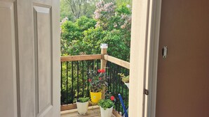 A wooden deck with potted plants and a welcome mat. - Issa place (Prince Edward)