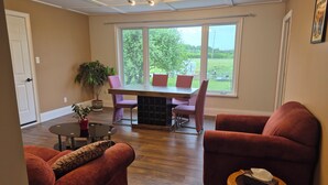 A dining area with a table and chairs, a potted plant, and a view of the outdoors. - Issa place (Prince Edward)