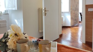 A room with a wooden floor, a white door, and a radiator.