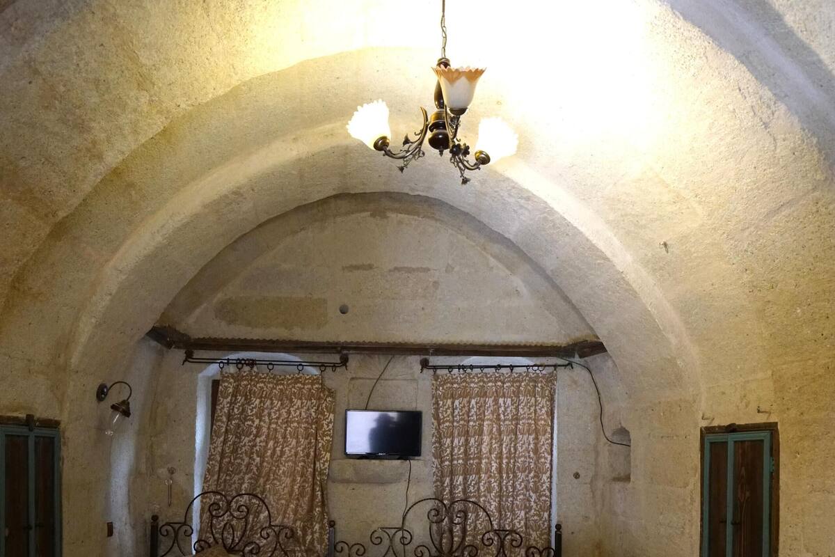 Ein Zimmer mit zwei Betten, einer Kristallleuchtre und einem Fernseher.
