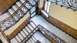 A multi-level staircase with ornate black railings and a central landing area. - LuxRent Penthouse Crimea (Turin)