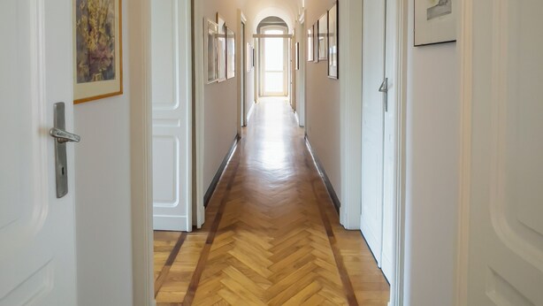 A hallway with wooden flooring, white walls, and framed pictures. - LuxRent Penthouse Crimea (Turin)