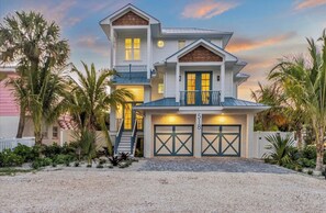 Ein zweistöckiges Haus mit Balkon, Garage und Auffahrt.