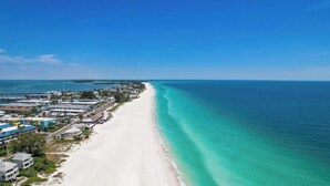 A coastal area with a long sandy beach and clear turquoise waters. - Amazing 6 bed house on Anna Maria! Putt putt, heated pool and spa! (Anna Maria)