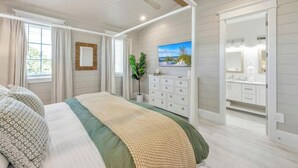 A bedroom with a bed, a dresser, a mirror, and a window with curtains. - Amazing 6 bed house on Anna Maria! Putt putt, heated pool and spa! (Anna Maria)