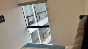 A modern living room with a large window, a sofa, and a patterned rug. - Modern apartment Vallecito (Arequipa)