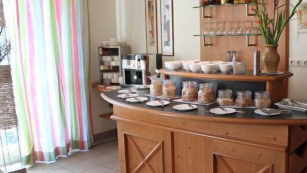 A breakfast bar with jars of spreads, plates, and glasses. - Lachnerhof (Erlangen)