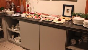 A kitchen counter with various dishes and utensils, a coffee maker, and a framed picture on the wall. - Lachnerhof (Erlangen)